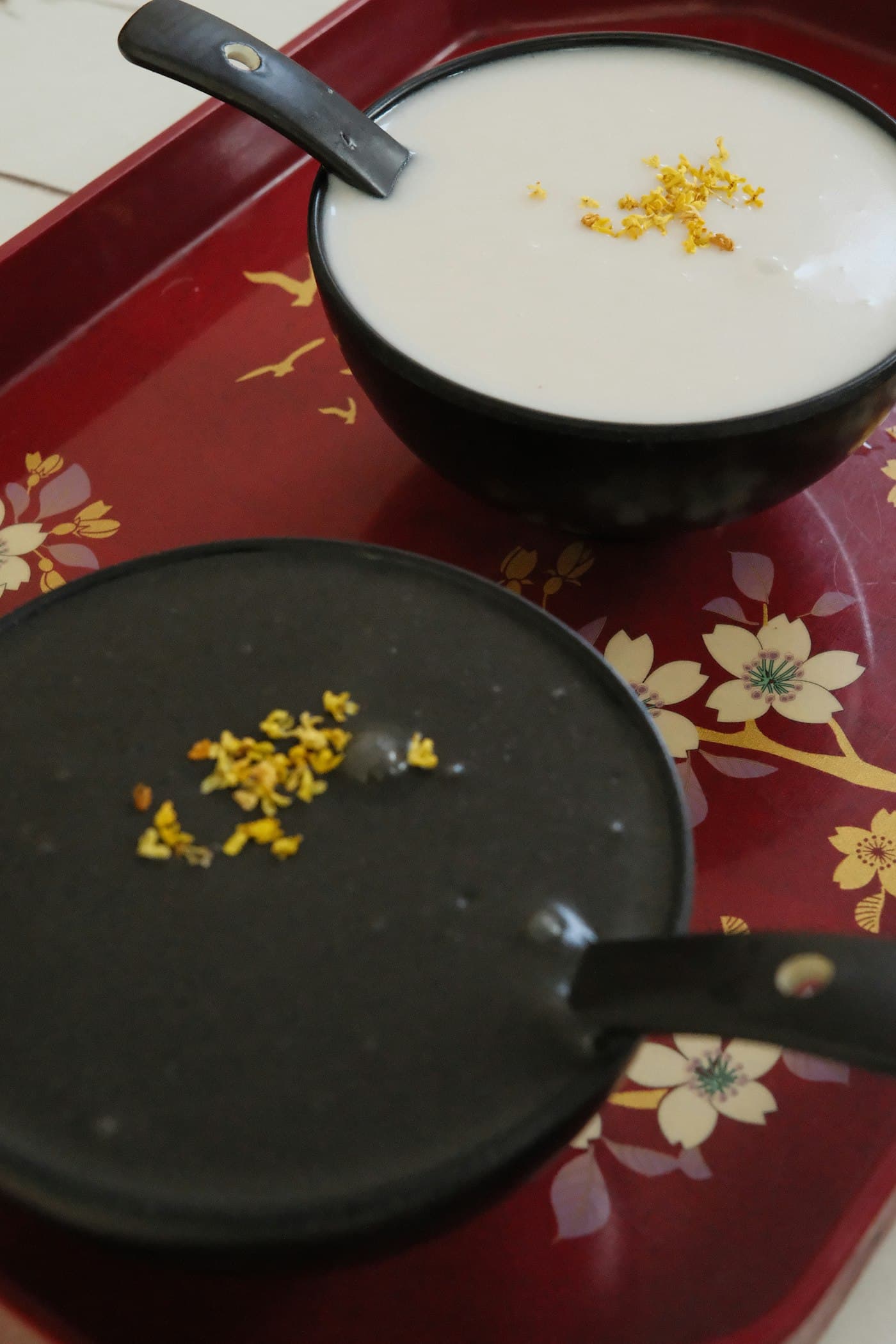 Two bowls of sweet osmanthus dessert on a red tray