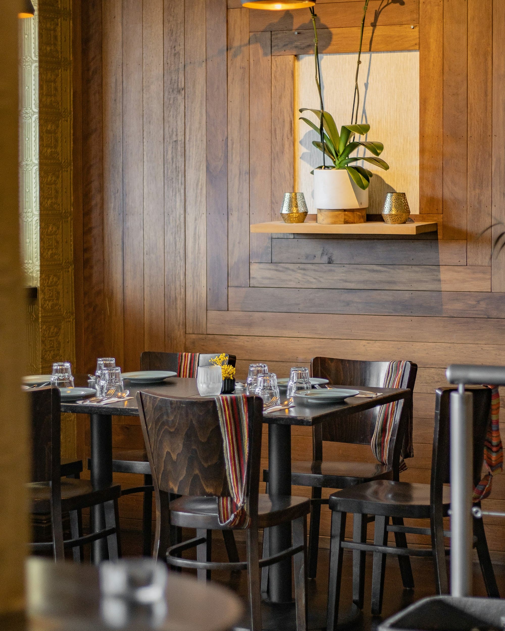 A dining room with dark timber walls and warm lighting