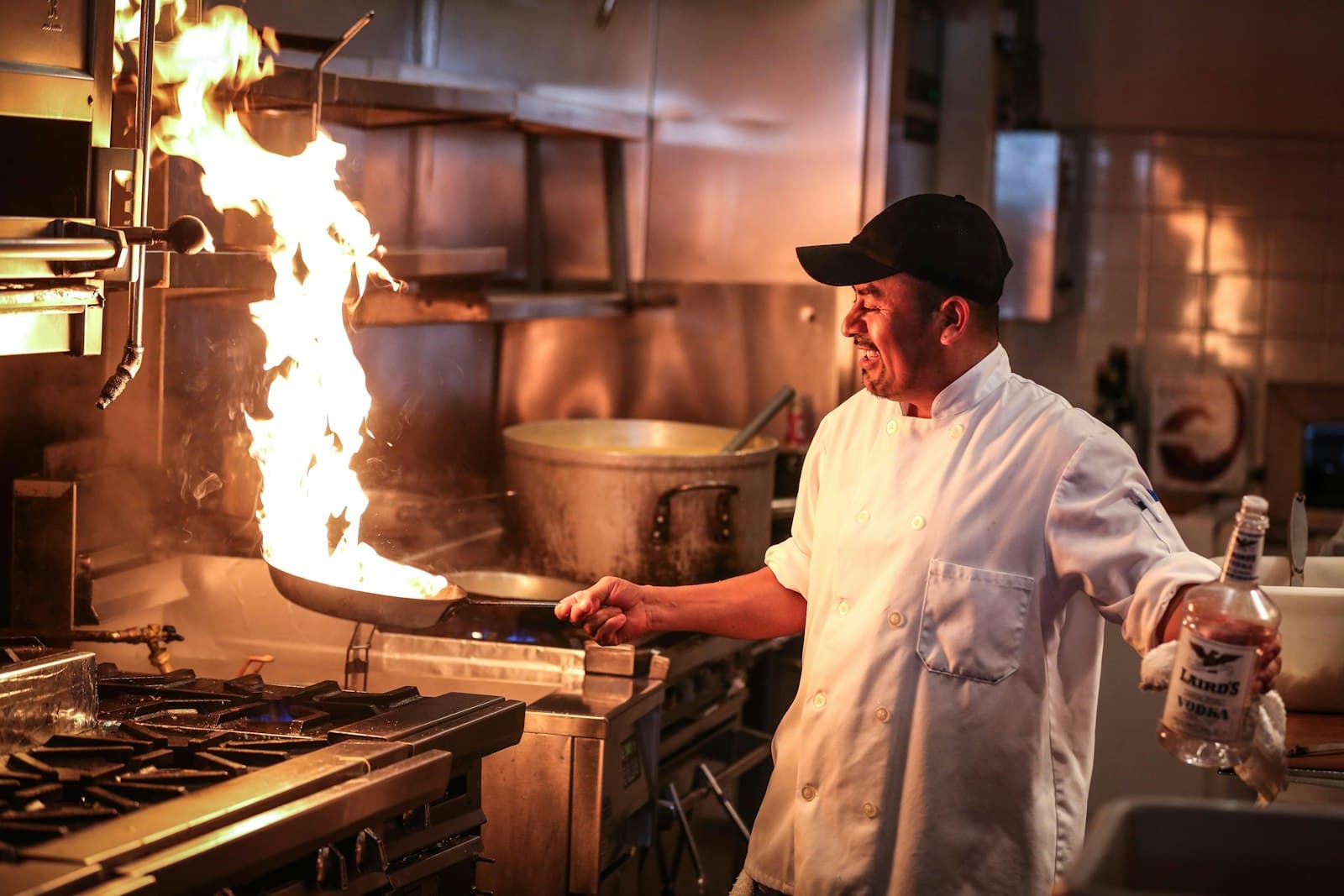 A chef tossing a wok over an open flame