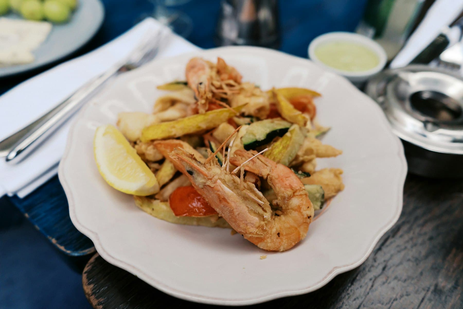 King prawns with vegetables plated on a white dish