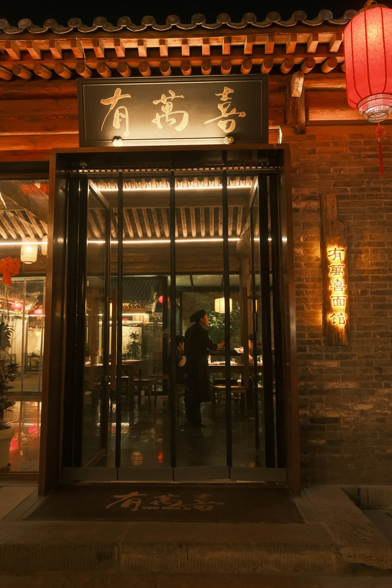 A restaurant entrance glowing with lanterns at night