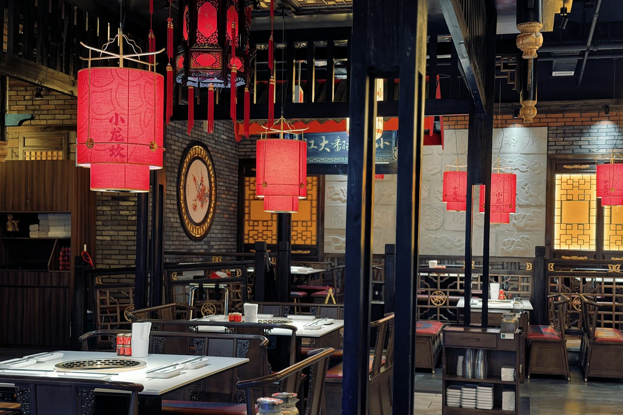 Restaurant dining room lit by red hanging lanterns